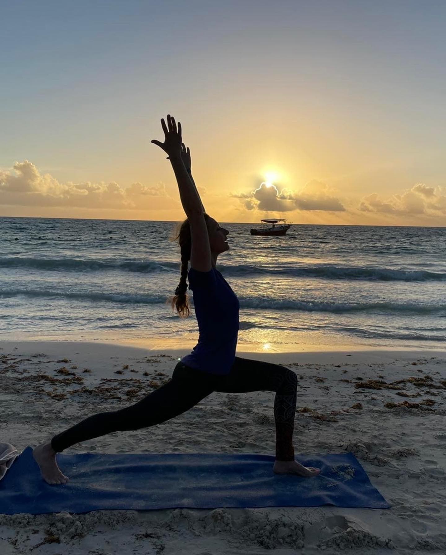 Savelia practicing yoga on the beach at sunset