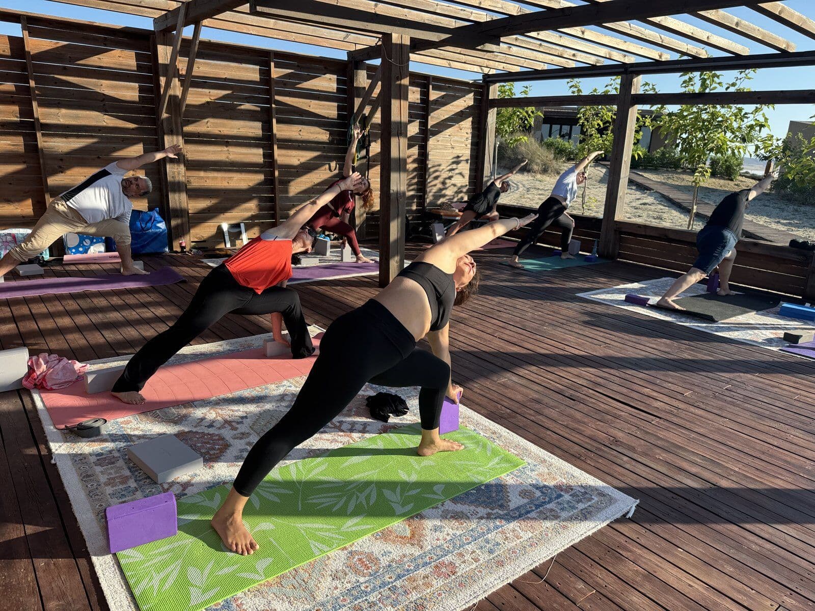 Warrior pose practice on an open-air wooden deck
