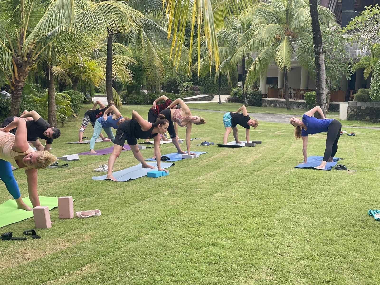 Group practice on the grass surrounded by palm trees